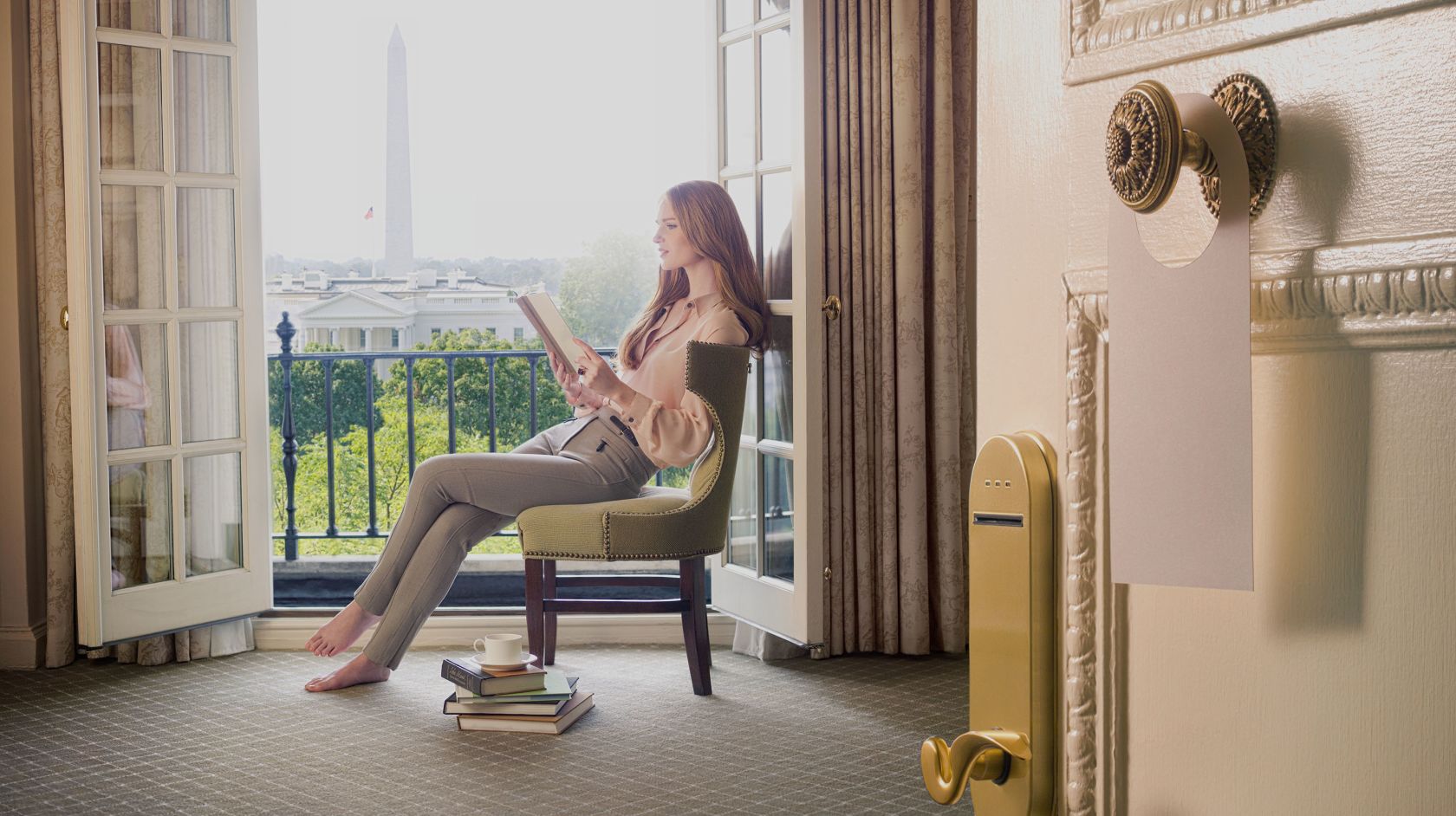Woman at Hay Adams reading a book overlooking the Washington Monument in Washington D.C.