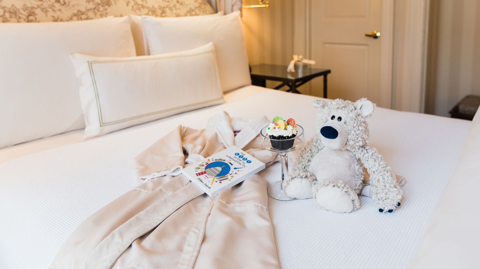 Stuffed Bear, Robe &amp; Toys Spread on Bed at Hay Adams