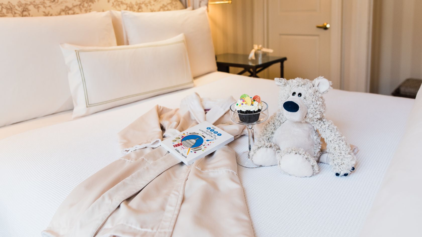 Stuffed Bear, Robe &amp; Toys Spread on Bed at Hay Adams