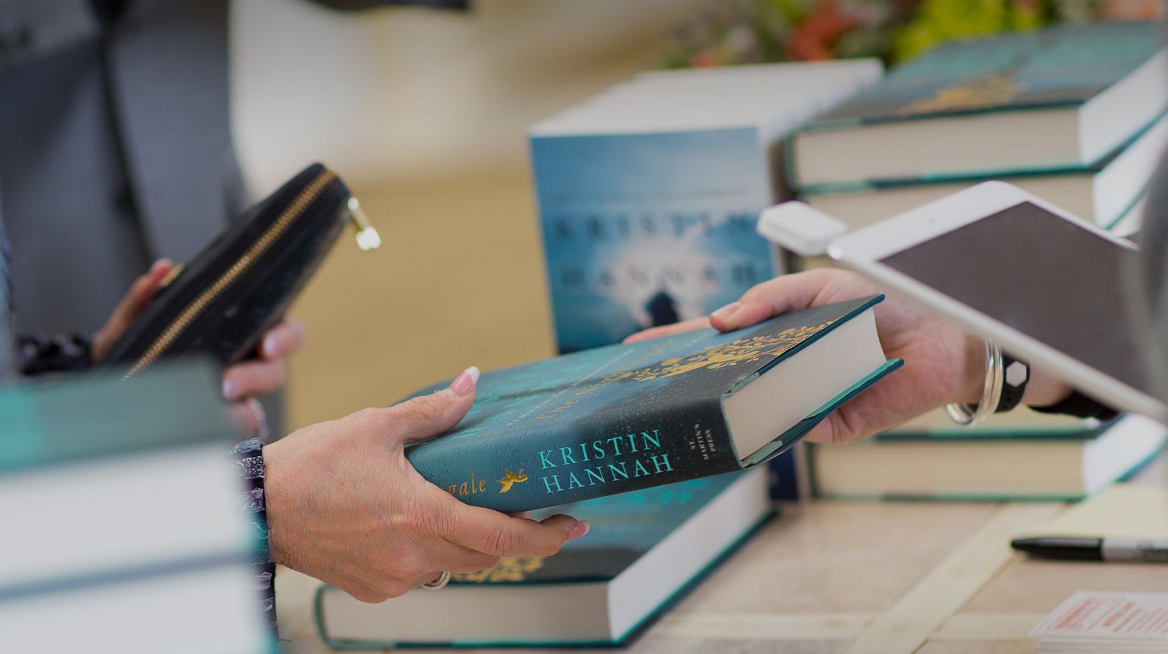 Kristin Hannah signing copies of her book at the Author Series event